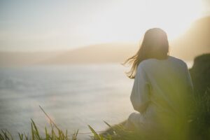 Woman enjoying a calm moment by the lake.